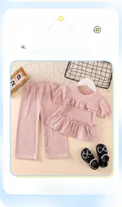 Detail of pink girls' short sleeve set showing textured pleated fabric and ruffle sleeves