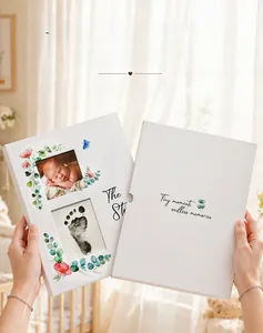 Detailed view of white baby memory book featuring infant footprints and floral illustrations