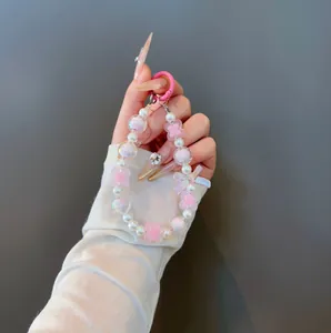 Cute beaded phone strap with pink bow, four-leaf clover, and pearls for backpack decor