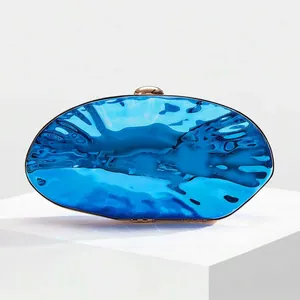 Detailed macro of the blue metallic shell clutch showing unique liquid water ripple texture