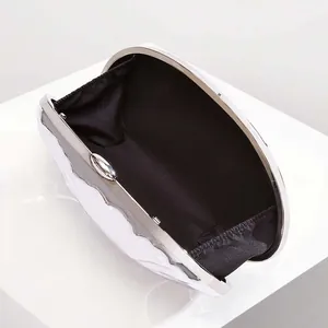Detailed interior of shell evening bag with black lining and silver metal frame