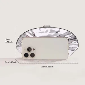 Metallic silver evening bag with size dimensions and phone scale reference for capacity