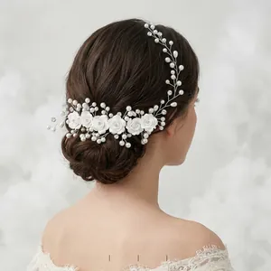 Detail of bridal hair comb with white ceramic flowers, pearls and crystal accents