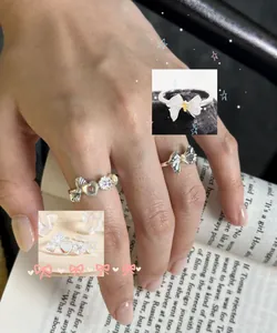 Detail shot of S925 sterling silver bow and heart rings with moonstone inlay on fingers