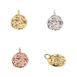Detailed view of round hammered pendants with colorful zircons in gold and silver plating