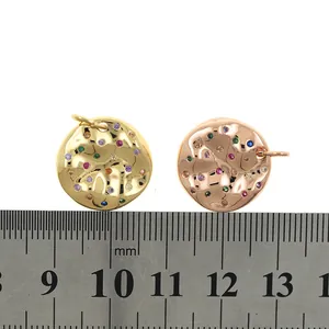 Gold plated circular pendant with colorful zircon stones measured on a steel ruler