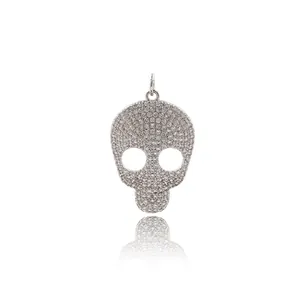 Macro view of silver skull pendant with sparkling full diamond pavé setting and top ring
