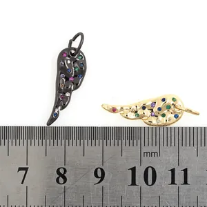 Gold and black wing pendants with colorful zircons shown with scale measurement