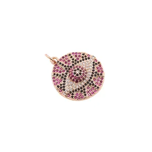 Macro detail of round evil eye pendant with pink cubic zirconia in rose gold plating