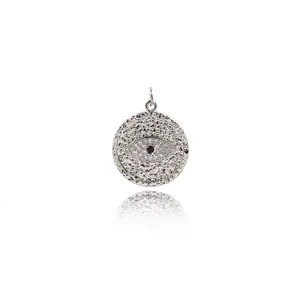 Macro detail of silver evil eye pendant with hammered texture and cubic zirconia