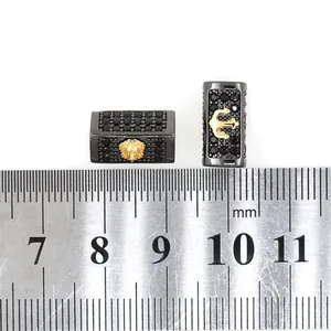 Macro shot of micro-paved lion and anchor beads with measuring scale for size reference