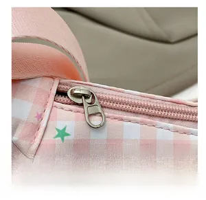 Detail view of the smooth silver zipper and stitching on a pink plaid dumpling bag