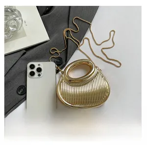 Mini sac de soirée doré texturé présenté à côté d'un téléphone pour la taille