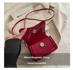 Détail du mini sac bandoulière en cuir verni rouge avec fermoir magnétique argenté