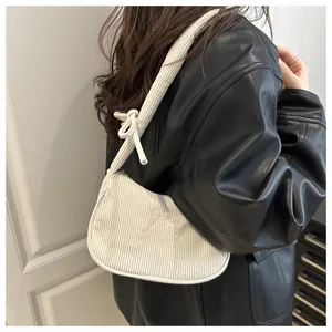 Détail d'un sac à bandoulière en velours côtelé blanc avec broderie nœud rose et nœud