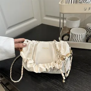 Chic beige pleated cloud handbag with gold chain strap and spherical charm detail