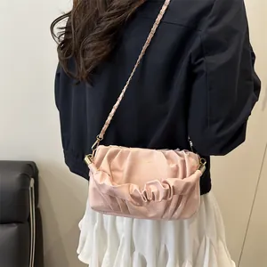 Pink pleated cloud shoulder bag with golden chain strap for women shown on model