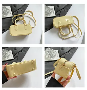 Detailed views of yellow patent leather Boston bag showing base studs and zip top closure