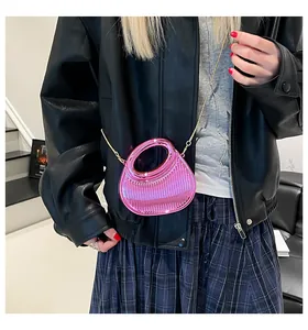 Détail du sac à main en acrylique rose brillant avec texture miroir et chaîne dorée