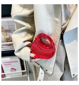 Détail du mini sac rouge en acrylique avec rayures verticales et poignée circulaire