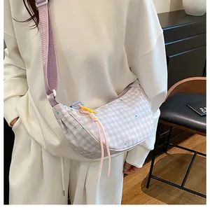 Detail of lavender checkered moon bag featuring colorful star prints and purple strap
