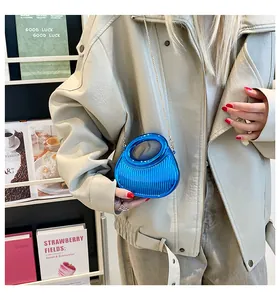 Détail du mini sac bleu en acrylique avec texture verticale et chaîne dorée élégante
