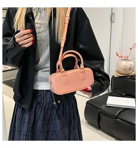 Pink candy-colored PVC cylinder bag detail showing smooth texture and adjustable strap