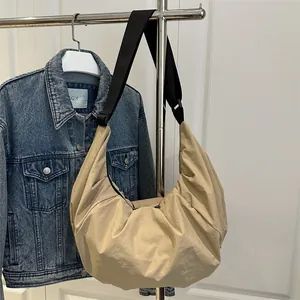 Sac à bandoulière beige minimaliste avec sangle noire et tissu en nylon plissé
