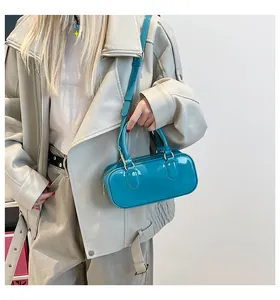 Detail of teal blue patent leather crossbody bag with glossy finish and top handle
