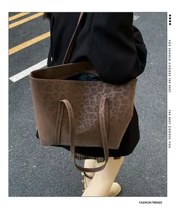 Outdoor street style shot of large brown leopard print tote bag on model shoulder