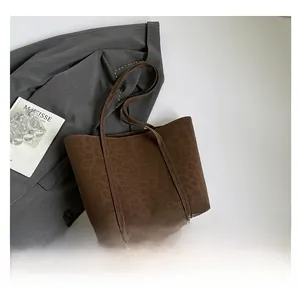 Macro view of leopard print texture and embossed suede on dark brown tote bag