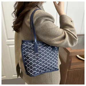 Détail du sac cabas bleu marine avec imprimé en Y et fines anses en cuir élégantes