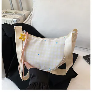 Detail of beige plaid crescent bag with colorful stars and yellow star charm hanger