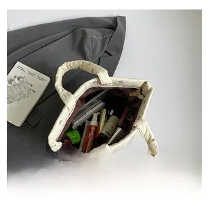 Detailansicht der cremefarbenen Stepptasche mit Schleifenstickerei und großem Innenraum