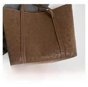 Detail view of large leopard print tote bag featuring brown faux leather embossed texture