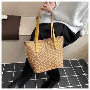 Gros plan d'un sac cabas jaune avec motif géométrique à écailles et anses en cuir