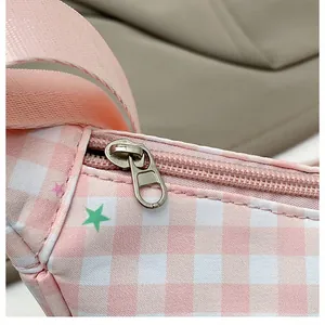 Detail of pink plaid bag showing silver metal zipper and durable nylon shoulder strap