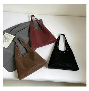 Detail view of leopard print tote bags with metal eyelet decor in various colors