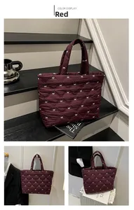 Detail der roten Stepptasche mit weißer Schleifenstickerei und glänzendem Nylon