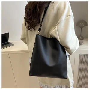Détail d'un sac cabas minimaliste en cuir noir avec bandoulière réglable au dos