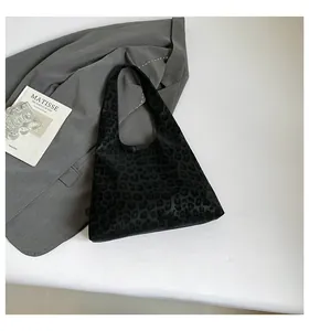 Detail of black leopard embossed tote bag on professional minimalist studio background