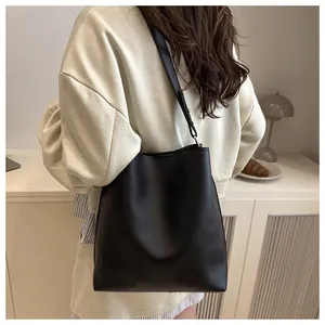 Vue mannequin montrant le grand sac seau en cuir noir drapé pour les déplacements quotidiens