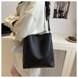 Sac seau minimaliste en cuir noir présenté dans un décor de bureau pour le style quotidien