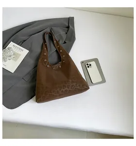Detail of leopard print hobo bag with silver metallic eyelets on the shoulder strap