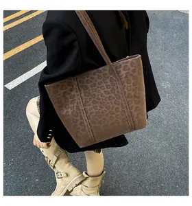 Outdoor street style view of a large leopard print tote bag styled with a chic outfit