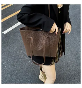 Detailed texture of brown leopard print tote bag with matte finish and metal buckle detail