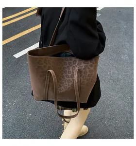 Street view of a stylish leopard print tote bag worn on shoulder for daily commute