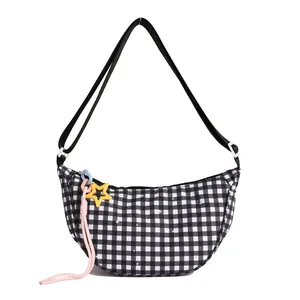 Checkered crescent crossbody bag with adjustable strap and yellow star pendant accessory
