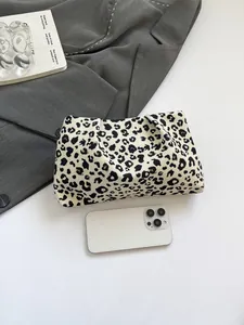 Pochette léopard en toile avec smartphone pour échelle sur fond gris élégant et sobre