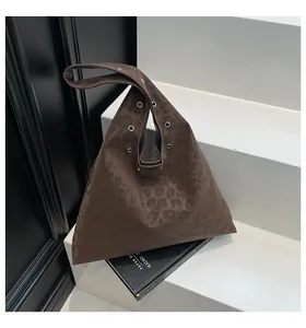 Detail view of the deep brown leopard print shoulder bag with silver metallic eyelets
